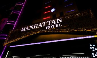 a nighttime view of the manhattan hotel , illuminated by colorful lights and decorated with christmas trees at Manhattan Hotel