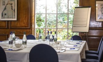 a conference room set up for a meeting , with several chairs arranged around a table at Portmeirion Village & Castell Deudraeth