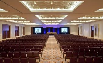 a large conference room with rows of chairs and two large screens on the stage at Sheraton Puerto Rico Resort & Casino