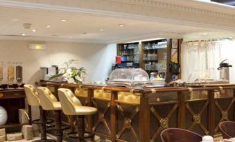 a well - lit bar area with a long wooden counter and several stools , creating a welcoming atmosphere at Napoleon