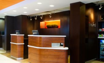 a modern hotel lobby with a check - in desk and a reception area , providing access to the guest services at Courtyard by Marriott Scranton Montage Mountain
