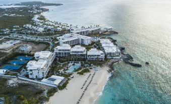 aerial view of a beach resort with multiple buildings , a pool , and the ocean in the background at Four Seasons Resort and Residence Anguilla