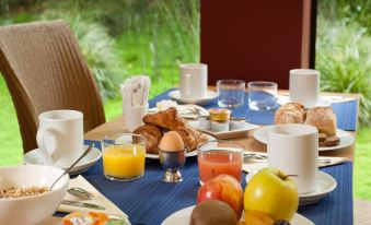 a dining table set with a variety of breakfast items , including plates of food , cups , and utensils at Ibis Styles Paris Mairie de Montreuil