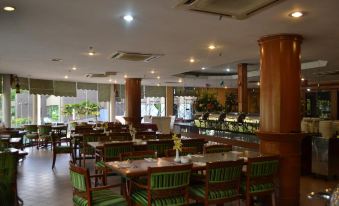 a large dining room with wooden tables and chairs arranged for a group of people to enjoy a meal together at De Rhu Beach Resort