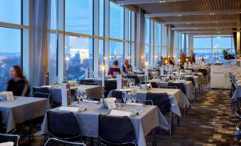 a large dining room with many tables and chairs arranged for a group of people at Gothia Towers & Upper House