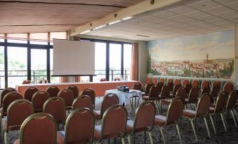 a conference room with a projector screen and chairs is set up for a meeting at Hotel Europa