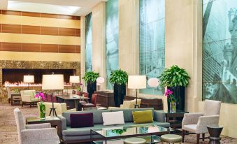 a large , well - lit hotel lobby with multiple couches and chairs arranged in various positions , creating a comfortable seating area at The Westin Chicago North Shore