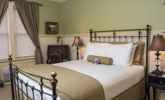 a cozy bedroom with a large bed , white sheets , and a teddy bear on the bed at Chamberlin Inn