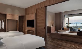 a modern bedroom with wooden walls , white beds , and a large mirror on the wall at Izu Marriott Hotel Shuzenji