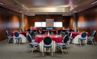 A spacious room is arranged with tables and chairs for hosting events or functions at VIP Executive Arts Hotel