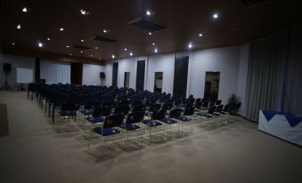 a large room with rows of chairs arranged in an auditorium - style seating arrangement , possibly for a meeting or presentation at Desert Cave Hotel