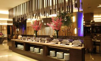 a long dining table filled with a variety of dishes and utensils , ready for a buffet - style meal at Hotel Horison Grand Serpong