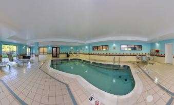 a large indoor swimming pool surrounded by a spa , with various amenities such as hot tubs , showers , and exercise equipment at SpringHill Suites Pittsburgh Mills