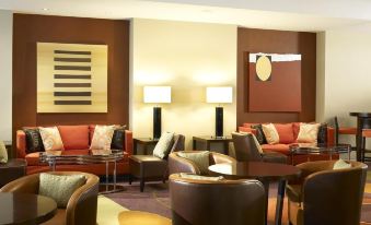 a cozy living room with multiple couches and chairs arranged around a coffee table , creating a comfortable and inviting atmosphere at London Twickenham Stadium Hotel, a Member of Radisson Individuals