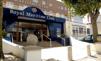 "a large building with a blue awning and a sign that says "" royal maritime club "" on it" at Royal Maritime Hotel