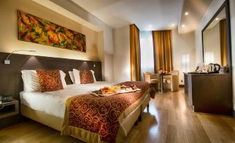 a large bed with a red and gold patterned blanket is in a hotel room at Hotel Diamante