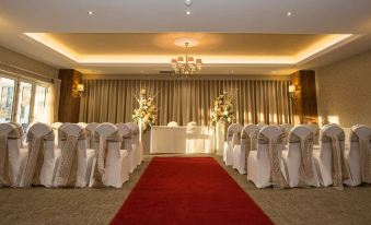 a wedding ceremony is taking place in a conference room , with rows of chairs set up for guests at Horsley Lodge