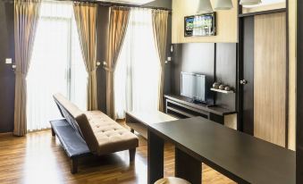 a modern living room with a couch , coffee table , and flat screen tv . also a dining table in the room at High Livin Apartment Baros