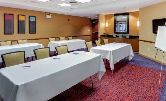 a conference room with multiple tables and chairs , each table covered with a white tablecloth at Residence Inn Auburn