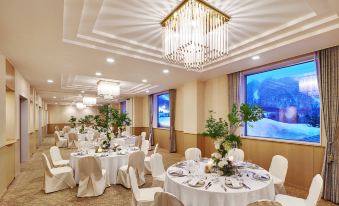 a large banquet hall with multiple round tables covered in white tablecloths and set for a formal event at The Westin Rusutsu Resort
