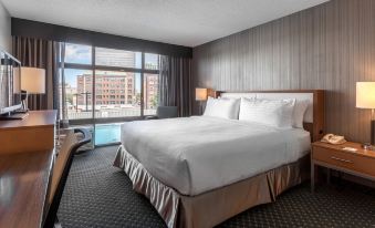 a large bed with white linens and a headboard is in a hotel room with a window at Holiday Inn Chicago North-Evanston, an IHG Hotel