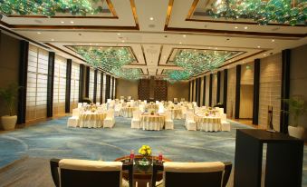 a large banquet hall with tables and chairs set up for a formal event , possibly a wedding reception at Crowne Plaza New Delhi Mayur Vihar Noida