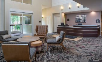 a hotel lobby with various seating options , including couches and chairs , as well as a reception desk at Sonesta ES Suites Nashville Brentwood