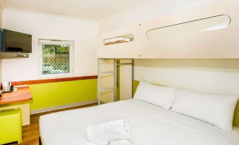 a bedroom with a white bed and green walls , featuring a bathroom next to it at Ibis Budget Windsor Brisbane
