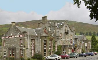 "a large stone building with the word "" hotel "" written on it , surrounded by cars parked in front of it" at Atholl Arms