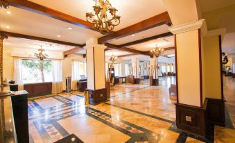 a large , ornate room with wooden beams and marble floors is beautifully lit by hanging chandeliers at Melia Panama Canal