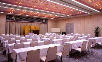 a large , empty conference room with rows of tables and chairs set up for a meeting or event at Todaya