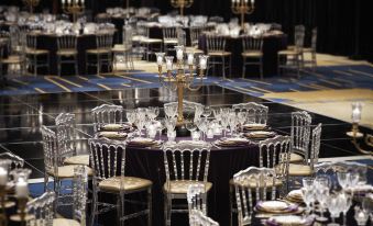 a lavishly decorated banquet hall with multiple dining tables , each set for a dinner party at Montreal Airport Marriott in-Terminal Hotel