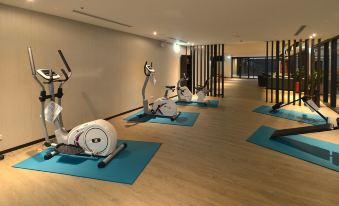a room with several exercise bikes lined up on the floor , indicating a gym or fitness center at Platinum Hotel
