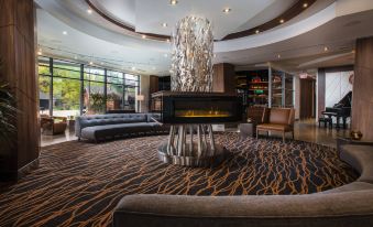 a luxurious hotel lobby with a fireplace and multiple couches , creating a warm and inviting atmosphere at Delta Hotels by Marriott Waterloo
