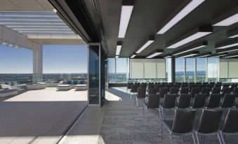 an empty conference room with rows of chairs and a large window overlooking the city at Aloft Perth