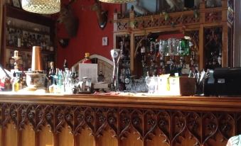 a wooden bar with various bottles and glasses on the counter , creating a cozy atmosphere at Chalk and Cheese