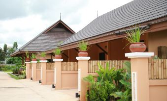 a row of buildings with pots on the pillars , and a clear sky above at Chalicha Resort