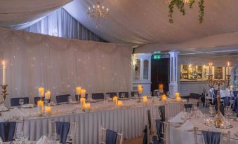 a well - decorated banquet hall with multiple dining tables and chairs set up for a formal event at Bunratty Castle Hotel