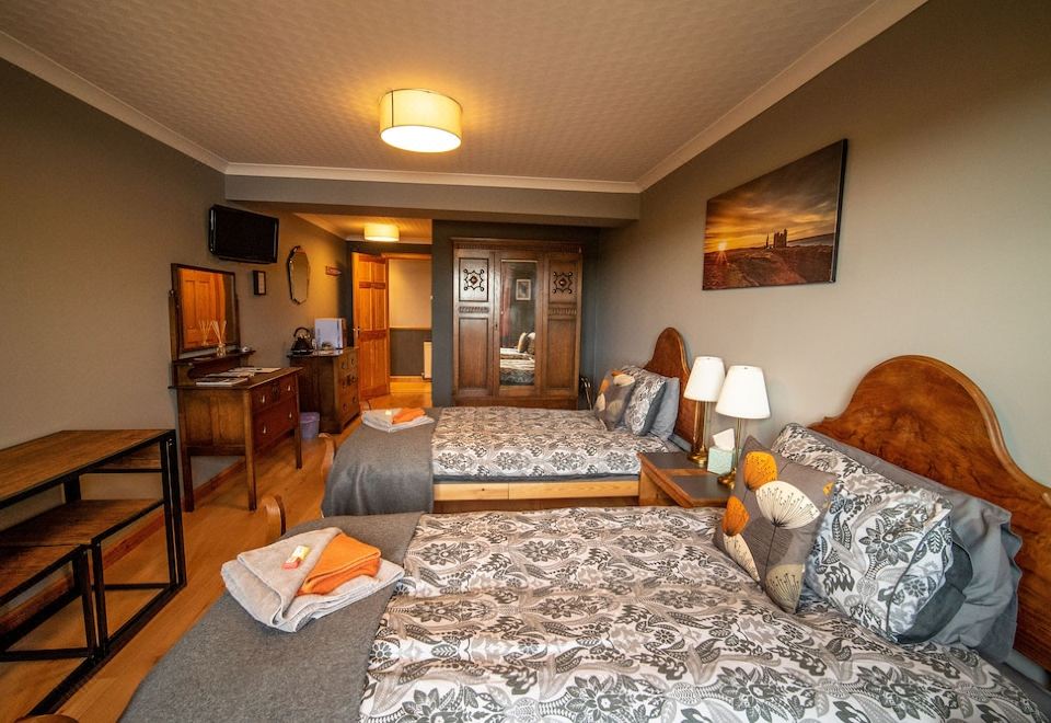 a hotel room with two beds , one on the left and one on the right side of the room at Burnside Cottage