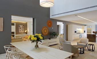 a modern living room with a dining area , featuring a white table and chairs , a couch , and a television at Crystalbrook Byron