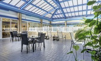 an outdoor dining area with a blue roof , allowing natural light to fill the space at Best Western Weymouth Hotel Rembrandt