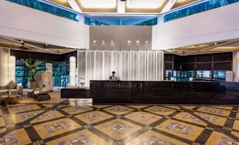 a modern hotel lobby with a reception desk , marble floors , and large windows that let in natural light at DoubleTree Resort by Hilton Hotel Penang