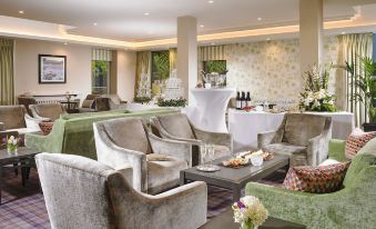 a well - decorated dining room with several chairs and couches arranged around a dining table , creating a comfortable atmosphere for guests at Actons Hotel Kinsale