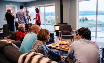 a group of people are gathered in a living room , sitting on couches and chairs , enjoying each other 's company while watching a movie on at Lakestone Lodge