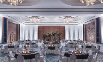 a large banquet hall is decorated with white tables , chairs , and chandeliers for a formal event at Shangri-La's Hambantota Golf Resort and Spa, Sri Lanka