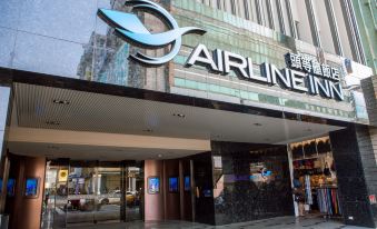 the entrance of an airline store with a large sign above it , and the name of the establishment is prominently displayed at Airline Inn Kaohsiung Station