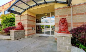 a brick building with two large red lions on either side of the entrance , creating a welcoming atmosphere at Red Lion Inn and Suites Victoria