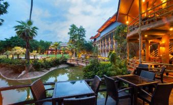 a resort with a pool surrounded by chairs and tables , as well as a dining area at Blues River Resort