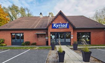 "the exterior of a building with a red roof and the sign "" kyriad rotterdam "" on it" at Kyriad Lille Est - Hem