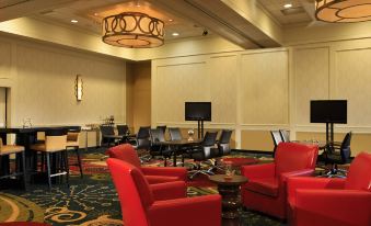 a hotel lobby with a red and black color scheme , featuring a large flat - screen tv mounted on the wall at Tysons Corner Marriott